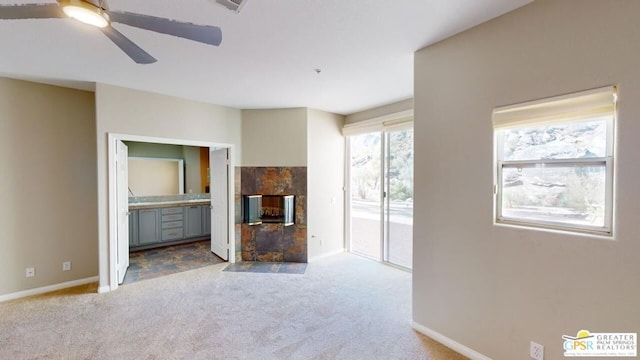 unfurnished living room with ceiling fan and carpet floors