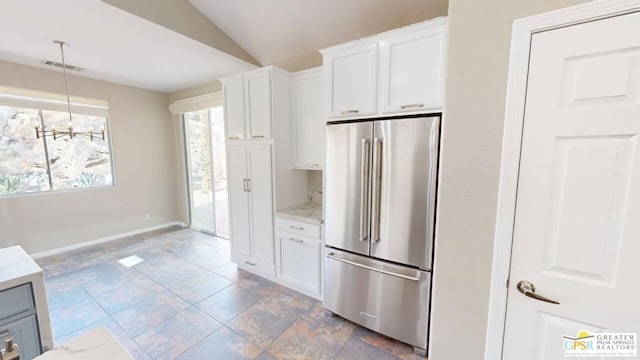 kitchen with hanging light fixtures, vaulted ceiling, high end refrigerator, and white cabinets