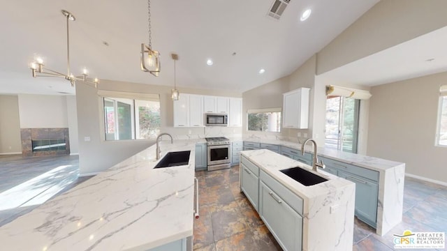 kitchen featuring sink, white cabinetry, hanging light fixtures, appliances with stainless steel finishes, and a kitchen island