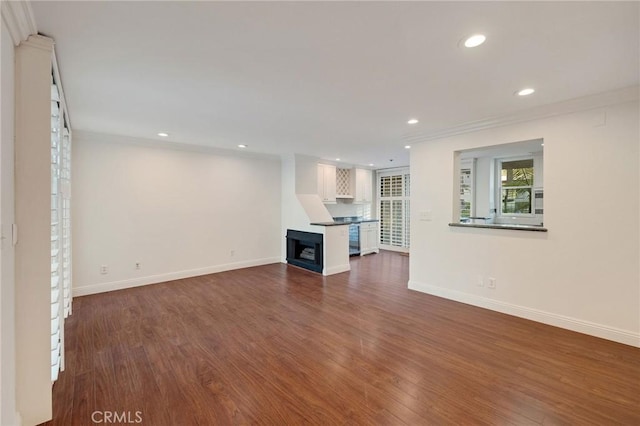 unfurnished living room with dark hardwood / wood-style flooring and crown molding