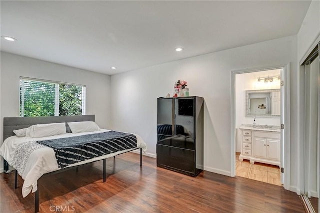 bedroom featuring connected bathroom, dark wood-type flooring, and sink