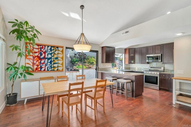 dining area with sink, dark wood-type flooring, and vaulted ceiling