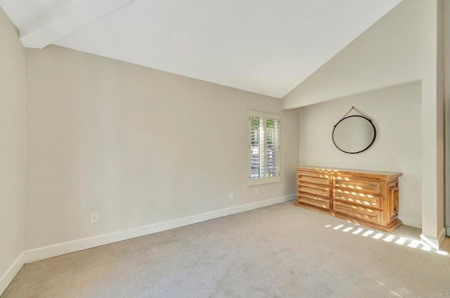 unfurnished bedroom with vaulted ceiling with beams and light colored carpet