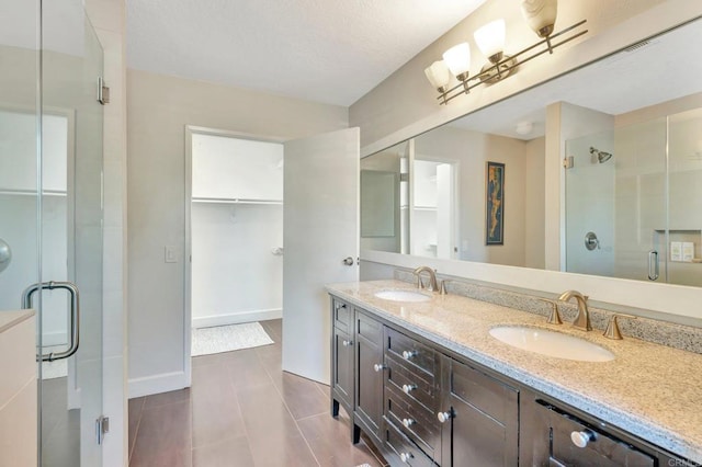 bathroom with tile patterned floors, vanity, and a shower with shower door