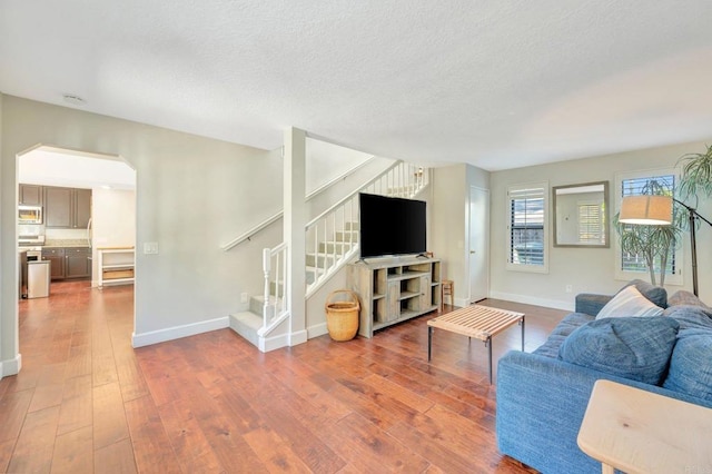 living room with wood-type flooring and a textured ceiling