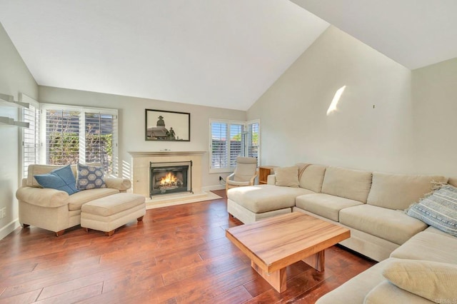 living room with plenty of natural light, high vaulted ceiling, and hardwood / wood-style floors