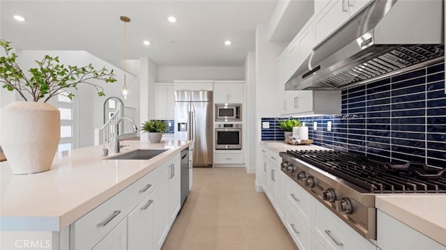 kitchen featuring sink, built in appliances, white cabinetry, and range hood