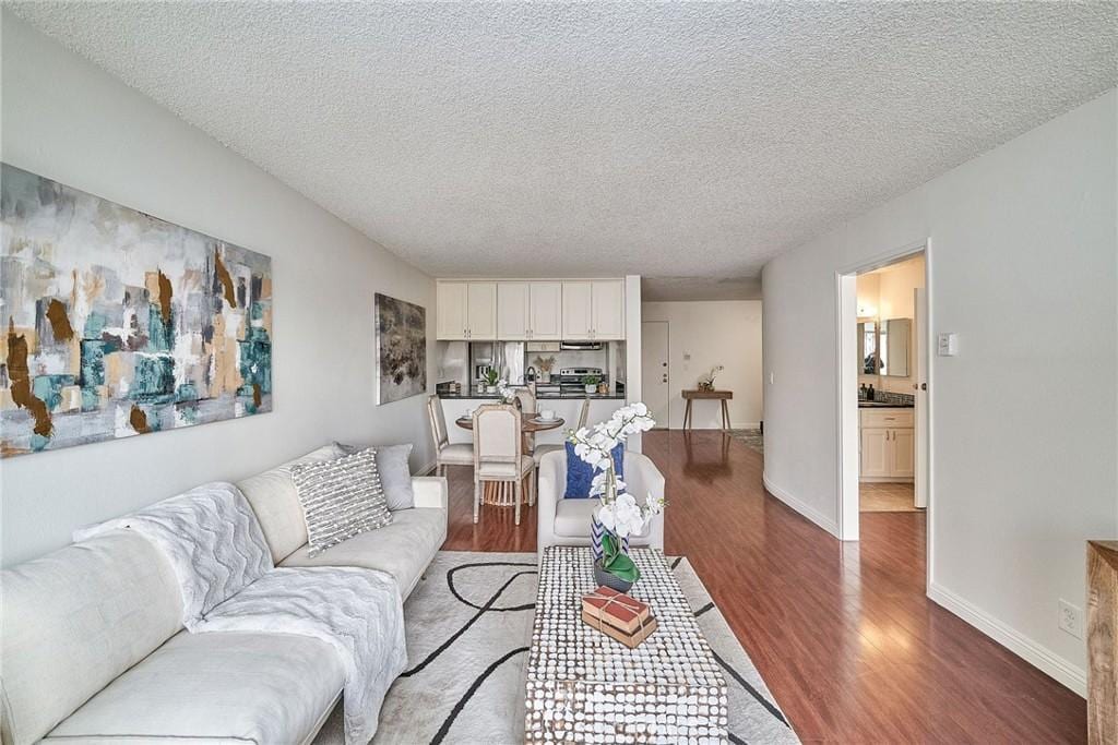 living room with a textured ceiling and dark wood-type flooring