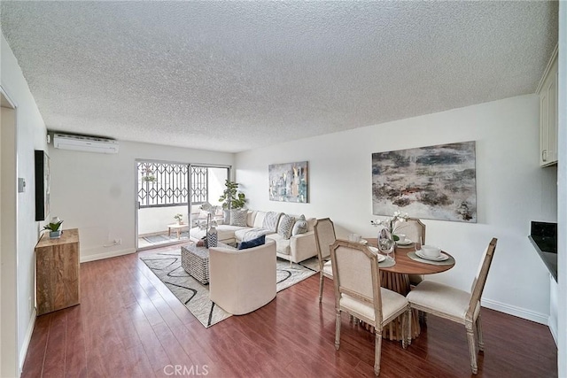 dining space with hardwood / wood-style floors, a wall mounted air conditioner, and a textured ceiling