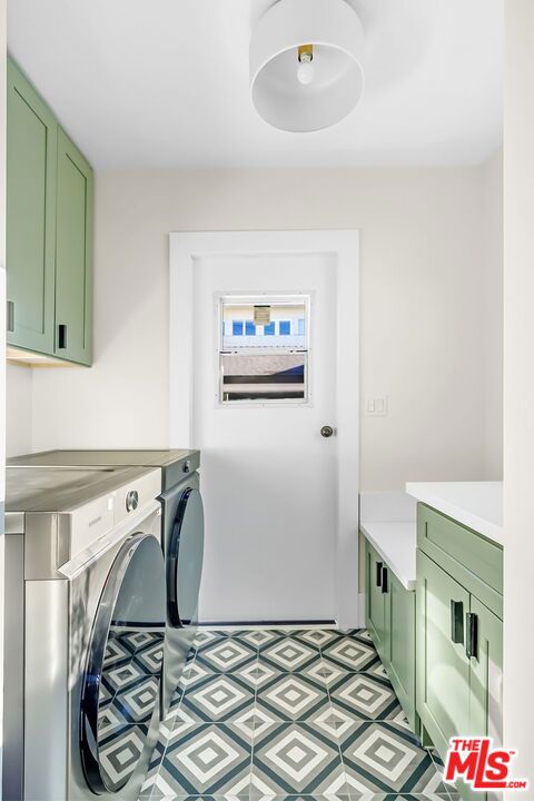 washroom with washer and clothes dryer and cabinets