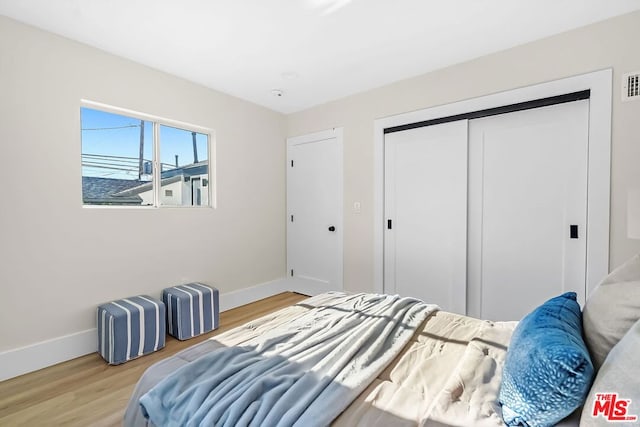 bedroom featuring light hardwood / wood-style floors and a closet