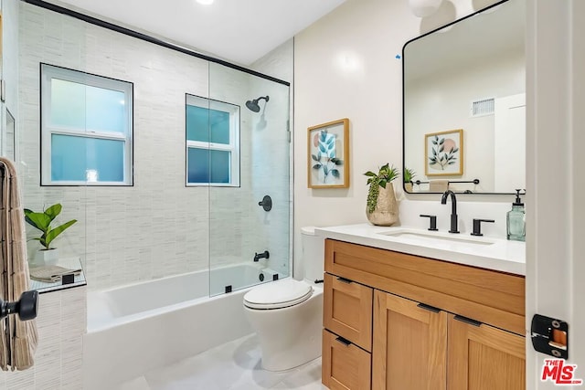 full bathroom with vanity, tiled shower / bath combo, tile patterned floors, and toilet