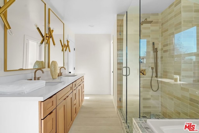 bathroom featuring walk in shower, vanity, and hardwood / wood-style flooring