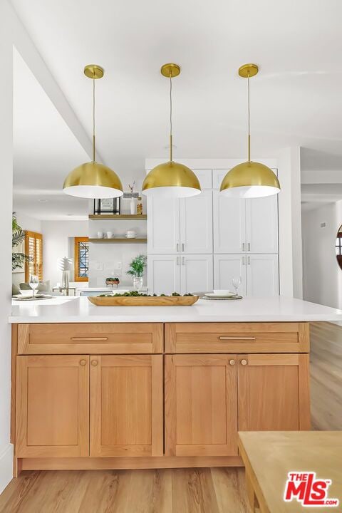 kitchen with pendant lighting and light hardwood / wood-style floors