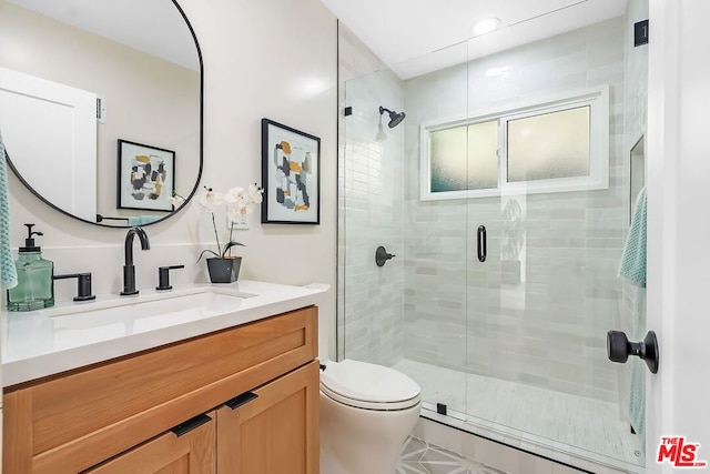 bathroom with vanity, toilet, and a shower with door