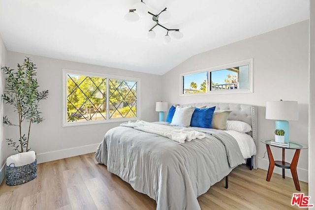 bedroom featuring lofted ceiling and light hardwood / wood-style flooring