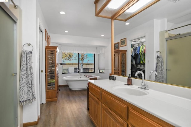 bathroom with hardwood / wood-style flooring, vanity, and separate shower and tub