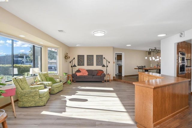 living room featuring bar area and light hardwood / wood-style floors