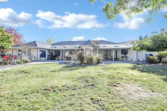 back of house with a lawn and a patio area