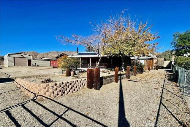 view of front facade featuring a garage, a mountain view, and an outbuilding