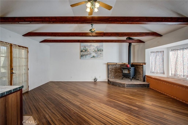 living room featuring vaulted ceiling with beams, hardwood / wood-style floors, ceiling fan, and a wood stove