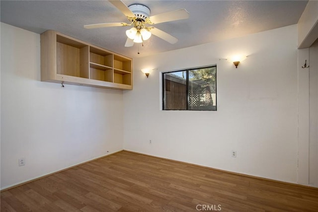 empty room featuring ceiling fan and hardwood / wood-style floors