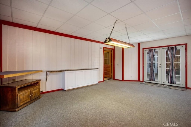 interior space with carpet, a drop ceiling, and french doors