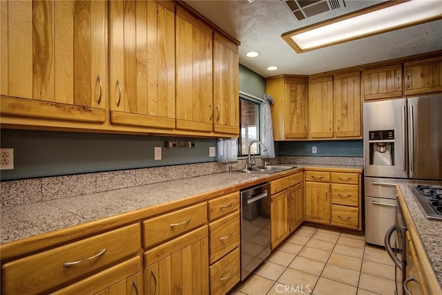 kitchen featuring appliances with stainless steel finishes, sink, and light tile patterned floors