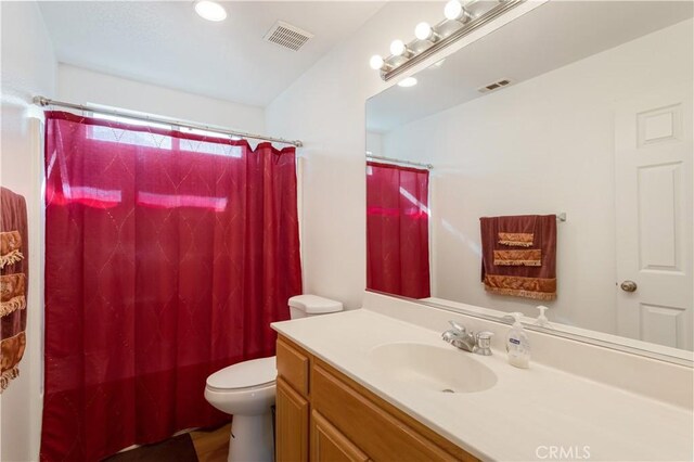 bathroom with vanity, curtained shower, and toilet