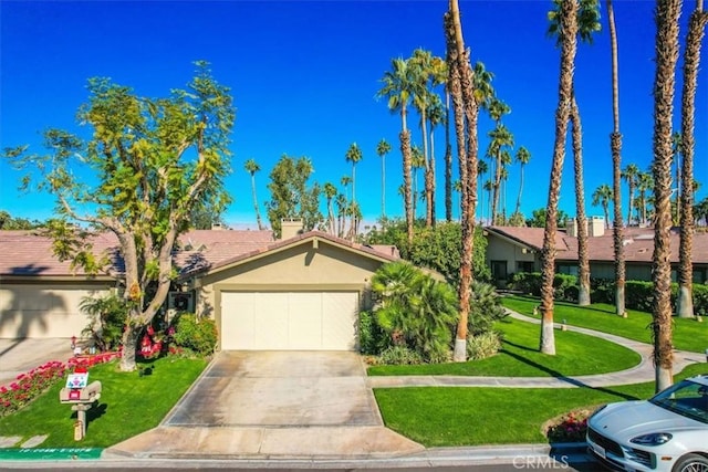 ranch-style home featuring a garage and a front lawn