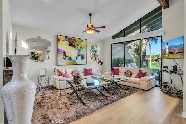 living room with hardwood / wood-style flooring, ceiling fan, and lofted ceiling