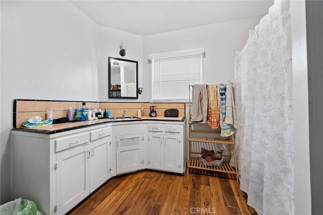 bathroom featuring vanity, hardwood / wood-style floors, and backsplash