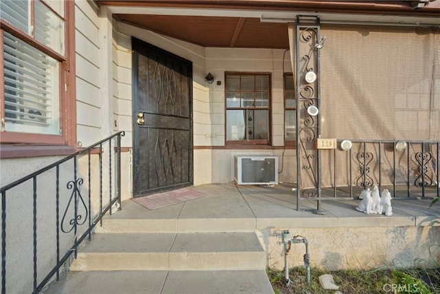 view of exterior entry with a wall mounted AC