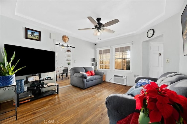 living room featuring ceiling fan, hardwood / wood-style floors, and a wall unit AC