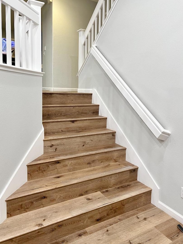 staircase with hardwood / wood-style flooring