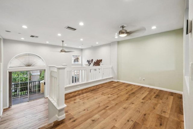 empty room with ceiling fan and light hardwood / wood-style flooring