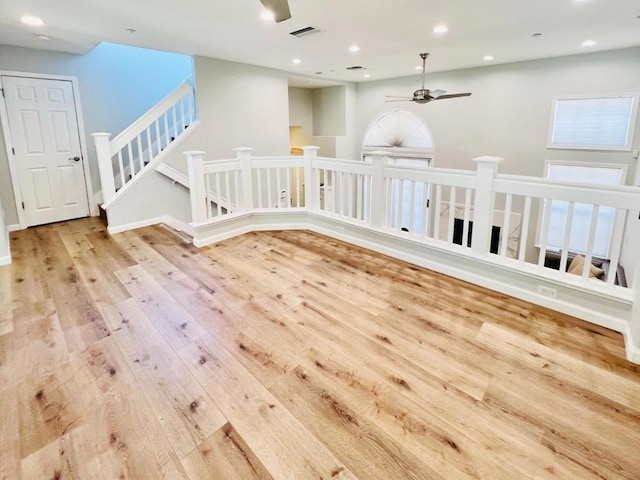 empty room with ceiling fan and light hardwood / wood-style flooring