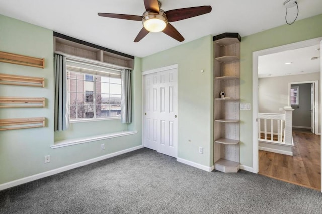 unfurnished bedroom featuring ceiling fan, a closet, and dark colored carpet