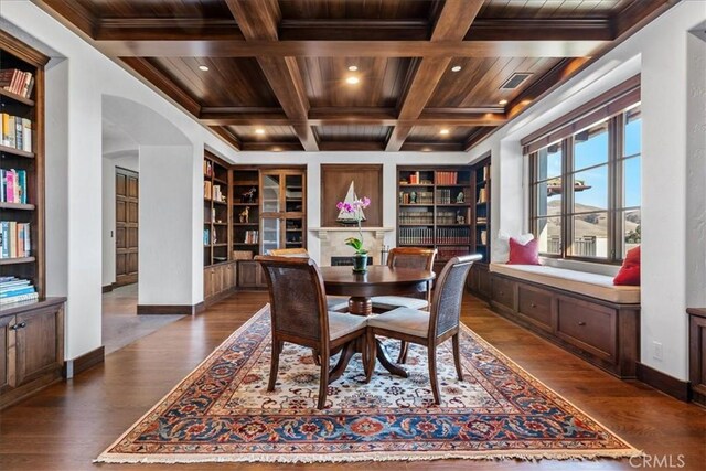 dining area featuring coffered ceiling, wood ceiling, built in shelves, dark wood-type flooring, and beamed ceiling