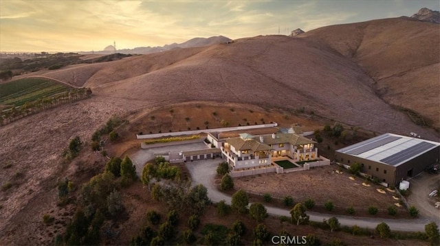 aerial view at dusk featuring a mountain view