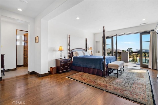 bedroom with access to exterior and hardwood / wood-style floors