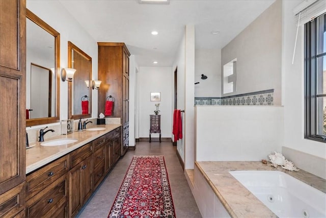 bathroom with tile patterned flooring, vanity, and tiled bath