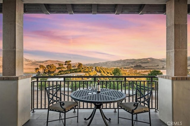 balcony at dusk featuring a mountain view