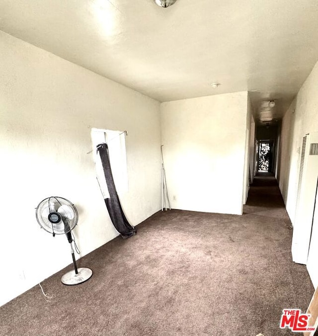 unfurnished room featuring dark carpet