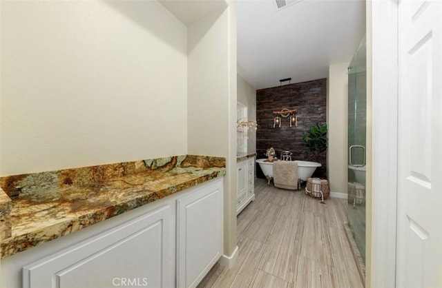 bathroom with plus walk in shower, wood-type flooring, and vanity