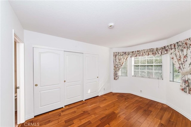 unfurnished bedroom featuring hardwood / wood-style floors and a closet