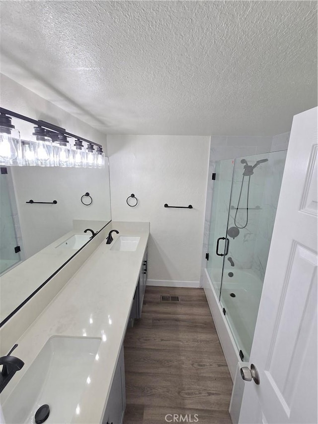 bathroom featuring walk in shower, vanity, a textured ceiling, and hardwood / wood-style flooring