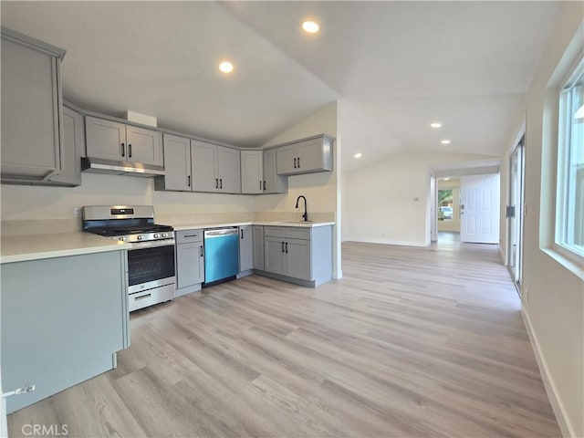 kitchen with lofted ceiling, sink, gray cabinets, and stainless steel appliances