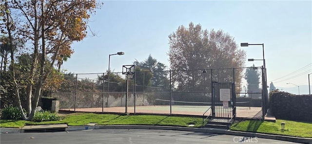 view of sport court featuring tennis court and a yard