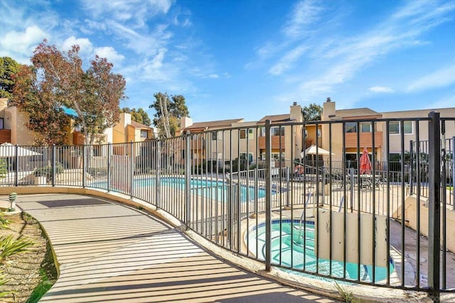 view of swimming pool with a community hot tub and a patio area